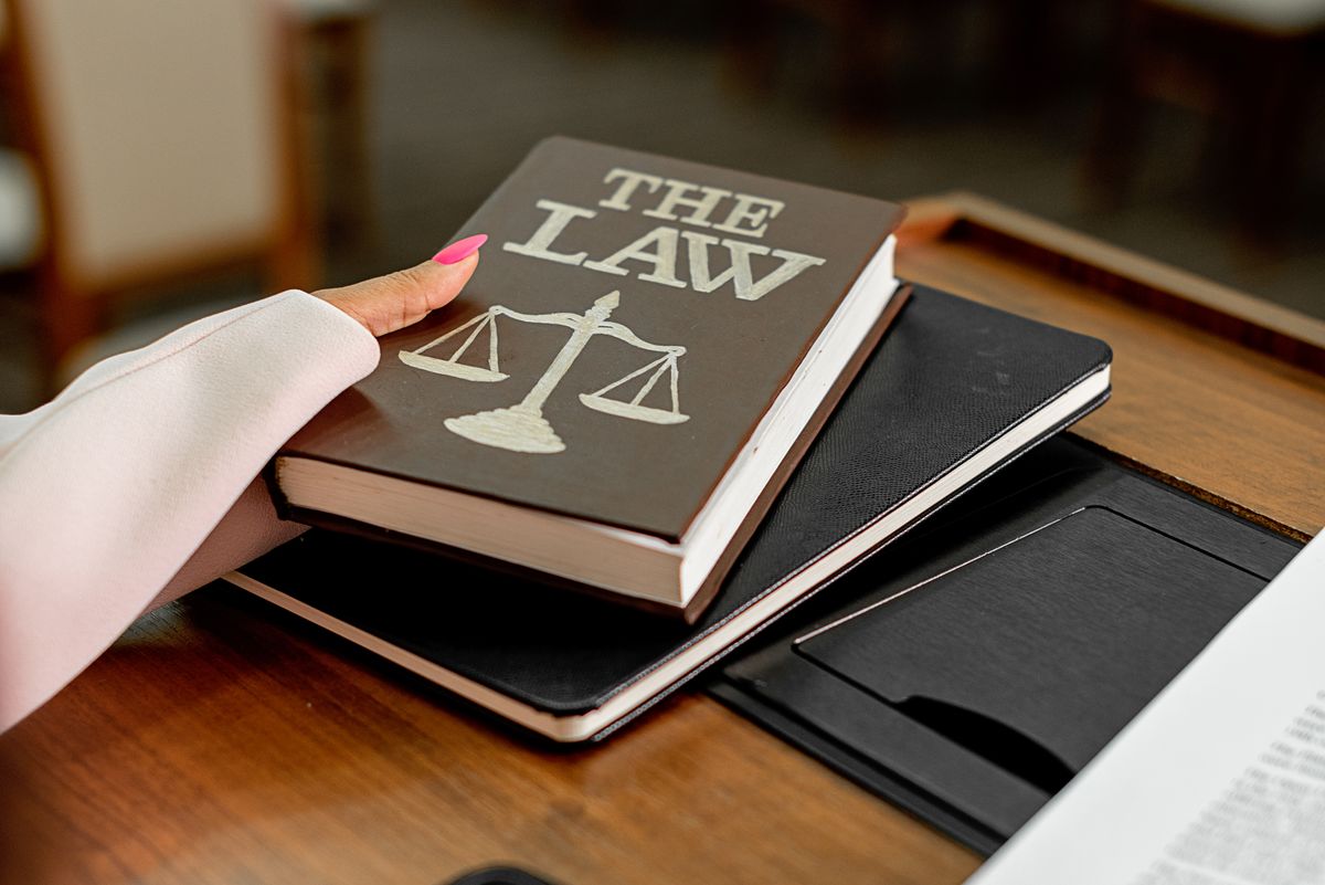 Libro de leyes y balanza de la justicia sobre un escritorio de madera